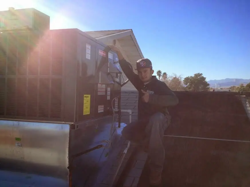 HVAC technician performing Heat Pump Repair on a rooftop unit in Portland